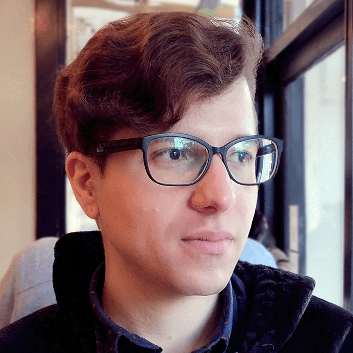 Photo of Luciano, person with short brown hair and glasses